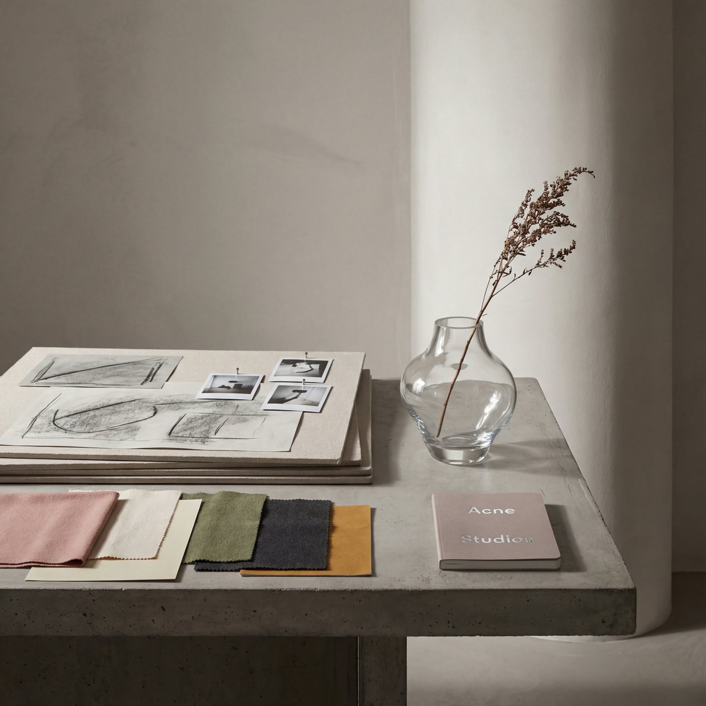Concrete table with mood board, fabric swatches, and dried botanicals.