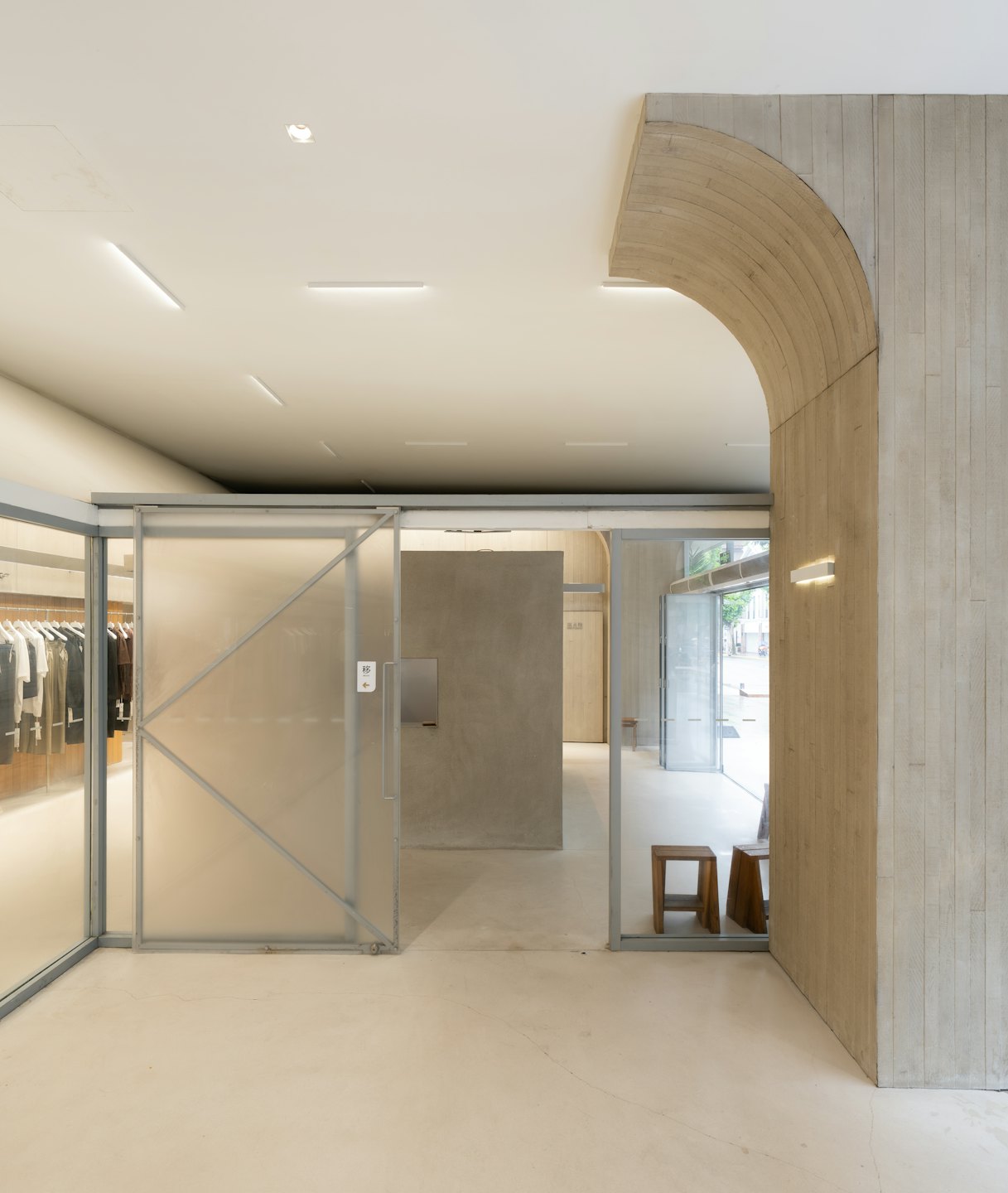 Modern retail store with concrete walls and clothing racks.
