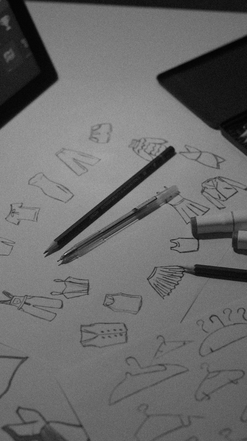 Fashion sketches and pens on a designer's desk.