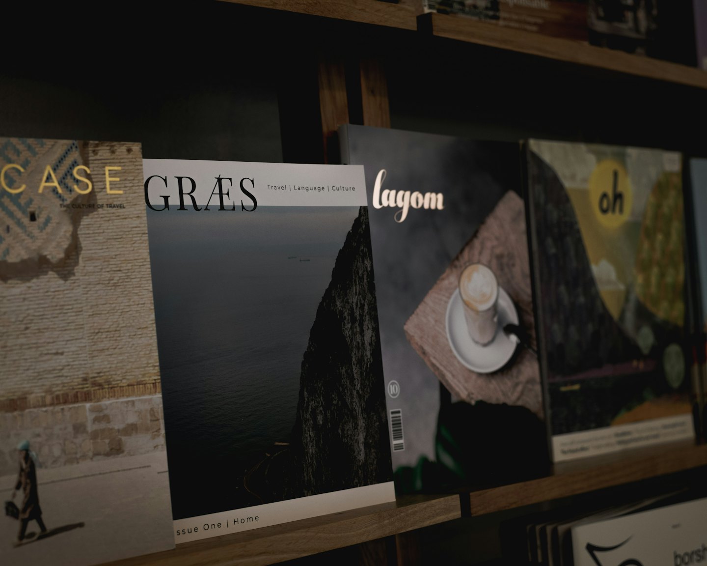 Magazines displayed upright on dark wooden shelves.